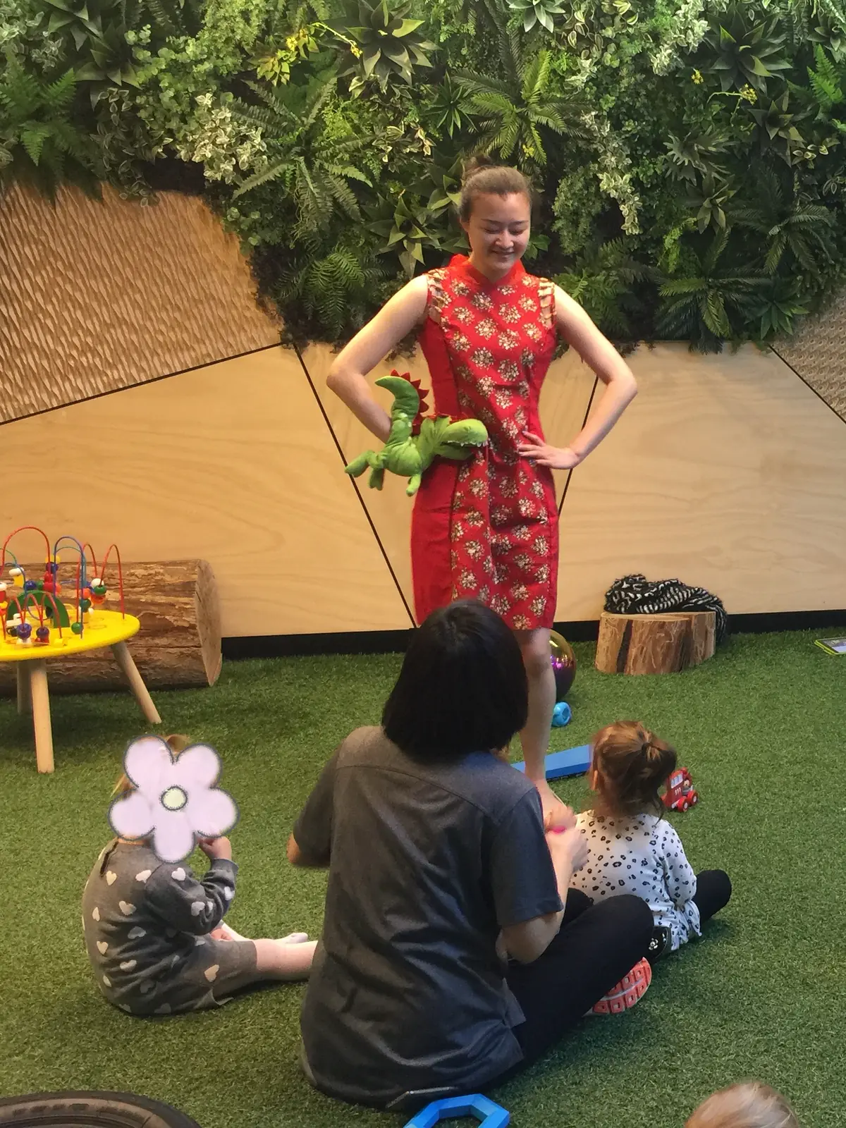 Raina leading a session with young children on a play mat