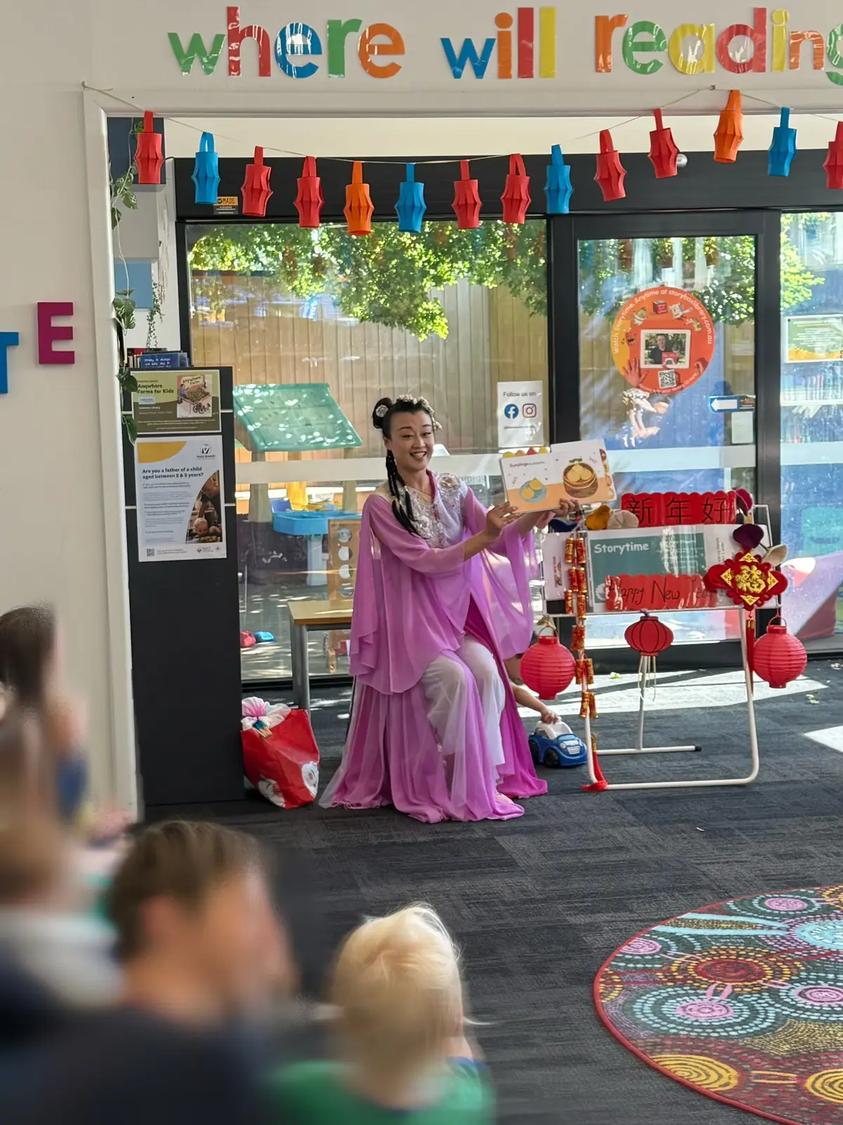 Raina reading a story to children at a library