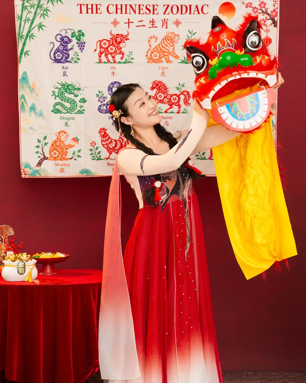 Raina lifting a lion dance head with a long yellow tail