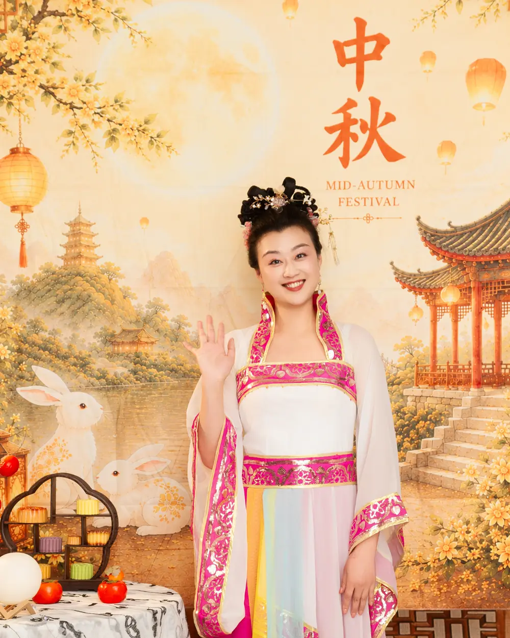 Raina waving beside a table of Mid-Autumn treats