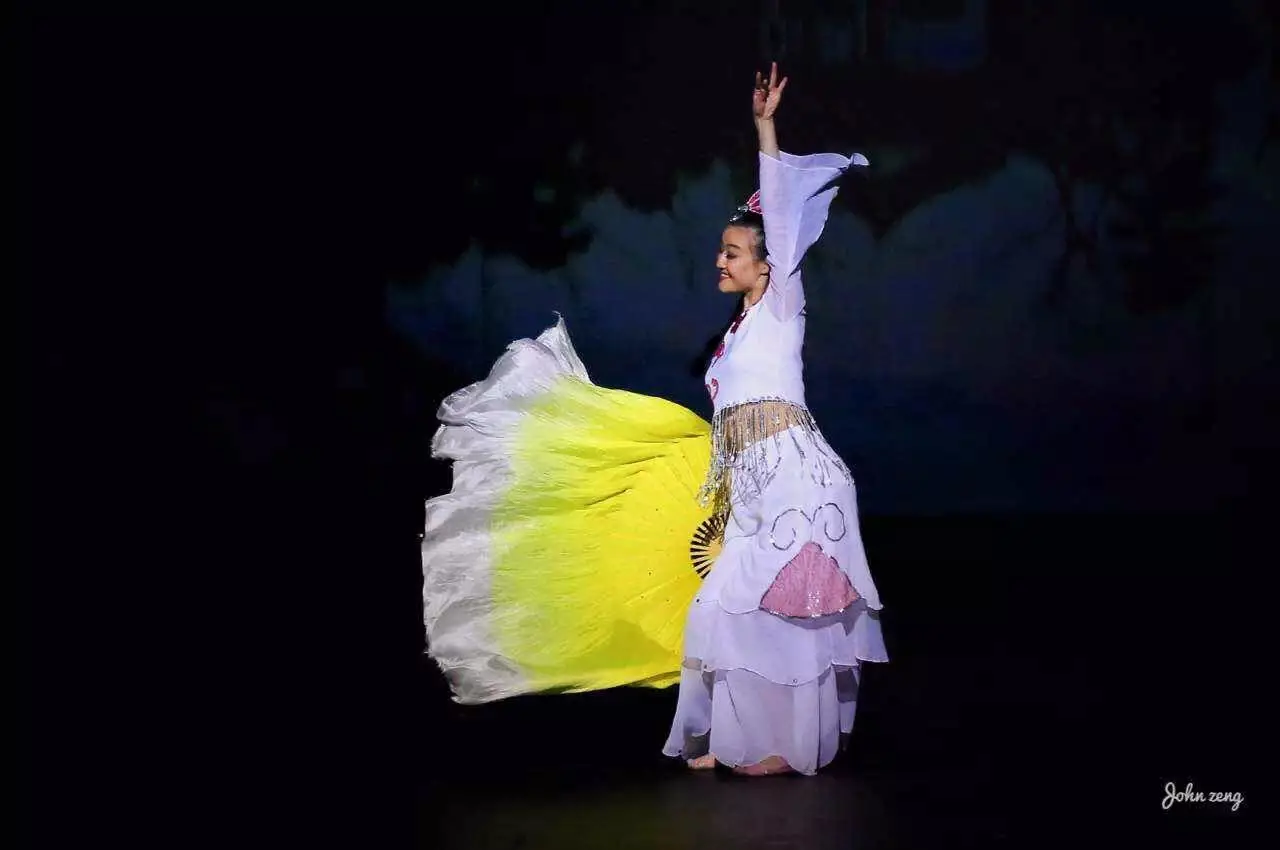 Raina performing with a yellow silk fan